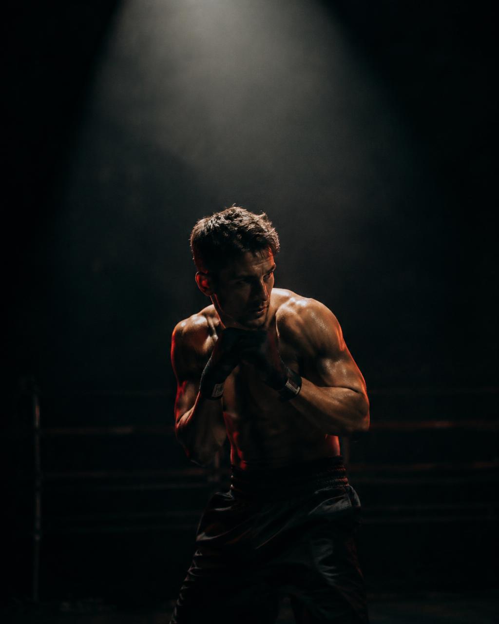 Athlete training alone under a single spotlight